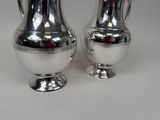 two silver vases sitting next to each other on a table