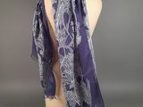a close up of a purple and white scarf on a mannequin head