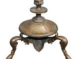 an antique brass oil lamp on a stand with a white background