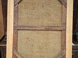 a wooden easel with a canvas on top of it in front of a wooden wall