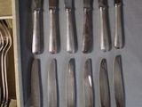 a lot of silverware on a table with a wooden box