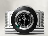 une horloge noire et argentée posée sur un socle en métal