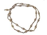 gros plan d'un collier en or avec une chaîne sur fond blanc