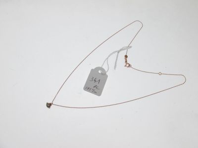 a necklace with a tag attached to it on a white surface