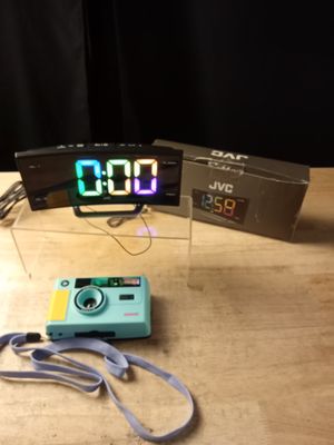 a small camera and a digital clock on a table