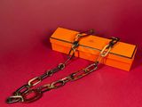 an orange box with chains and a pair of scissors on a red surface