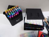 many pens and markers in a case on a table