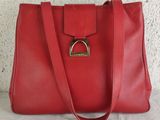 a red leather handbag with a metal ring on the handle