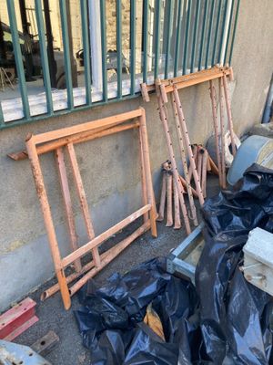 un tas d'ordures devant un immeuble, près d'une clôture