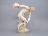 statue d'un homme tenant une balle dans la main