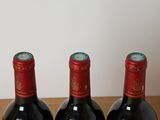 three bottles of wine sitting on a wooden table