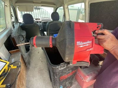 Quelqu'un utilise un outil Milwaukee pour démonter l'arrière d'une camionnette.