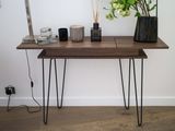 a wooden table with hairpin legs and vases on it