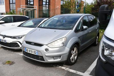 des voitures garées sur un parking devant un immeuble