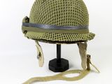 helmet on a black stand with a brown ribbon around it