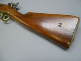a close up of a wooden rifle on a white surface
