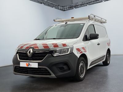 La camionnette blanche est garée dans une grande pièce aux murs à carreaux rouges et blancs.