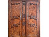 une photo d'une armoire en bois dont les portes sont ornées de sculptures