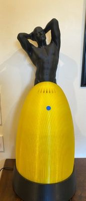 a statue of a man sitting on top of a yellow ball