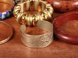 many different types of bracelets and bangles on a table