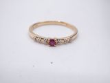 a yellow gold ring with a ruby and white diamonds
