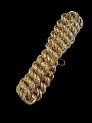 gros plan d'un bracelet en chaîne en or sur fond noir