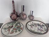 trois assiettes et deux vases posés sur une table