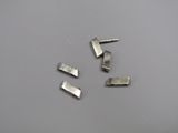four pieces of silver metal on a white surface