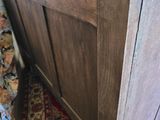 a wooden bed with a wooden headboard and a rug on the floor