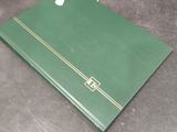a green folder with a gold stripe on it