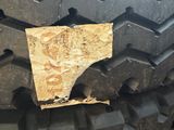a close up of a tire with a piece of wood on it