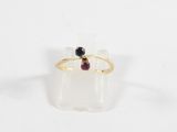 un gros plan d'une bague en or sertie d'une grenat