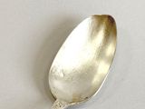 a spoon that is sitting on a white surface