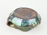 a green and blue bowl on a white surface