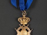 a gold medal with a blue ribbon and a crown on it