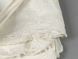 a close up of a folded white handkerchief on a gray surface