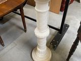 a white pedestal sink sitting in a room with chairs
