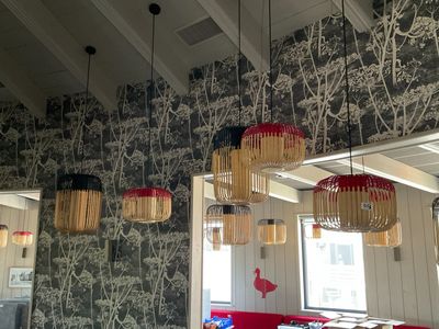 trois lampes suspendues au plafond au-dessus d'un canapé rouge