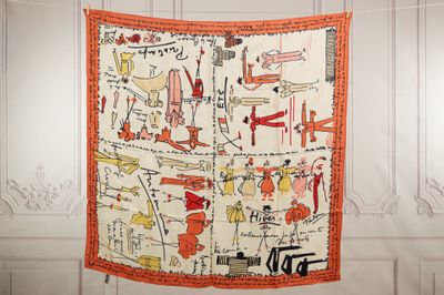 an orange and white scarf hanging on a white wall