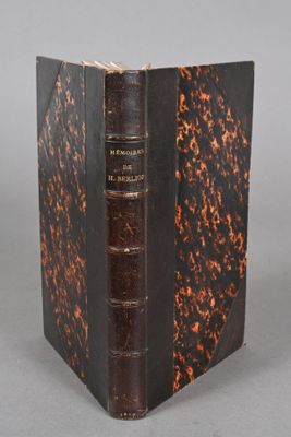 an old book sitting on top of a table next to a gray background