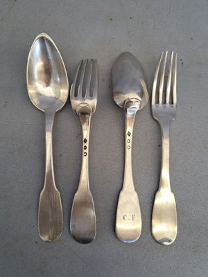 quatre cuillères en argent et deux cuillères en argent sur une table