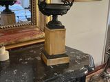 a vase on top of a dresser with a mirror in the background