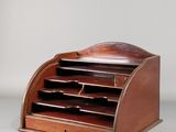 un vieux bureau en bois à trois tiroirs avec un pot à stylos