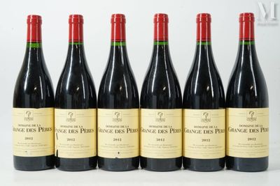 six bottles of red wine are lined up on a table