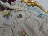 a figurine of a woman sitting on a chair
