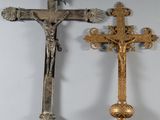 two crosses hanging on a wall in a room with white walls