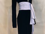 a black and white dress with a white sash on a mannequin base