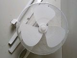 a white fan sitting on top of a table next to a knife