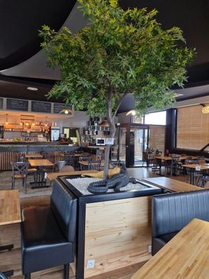 des tables et des chaises dans un restaurant avec un arbre au milieu de la salle