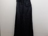 a black dress hanging on a hanger next to a white wall